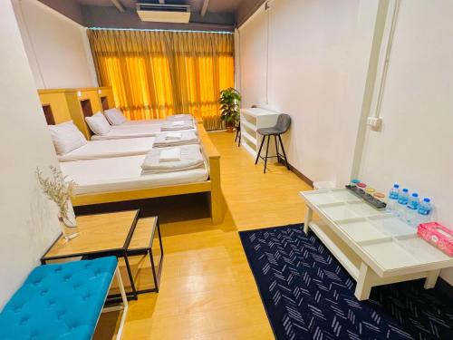 uma sala de estar com uma cama e uma mesa em Daraya Hostel em Bangkok