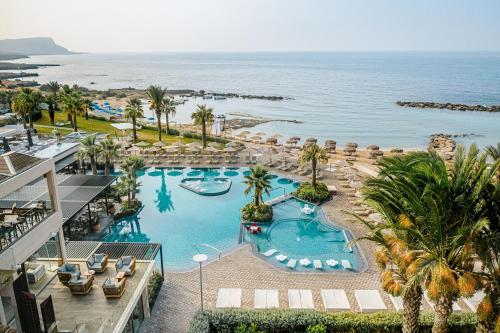 an aerial view of a resort with a pool and the ocean at Atlantica Mare Village Ayia Napa in Ayia Napa