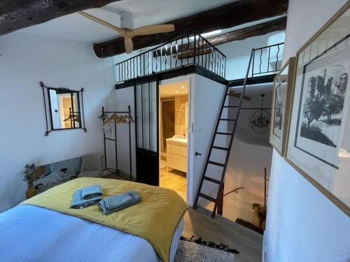 sypialnia z łóżkiem i spiralnymi schodami w obiekcie Duplex Atelier / coeur de Lourmarin w mieście Lourmarin