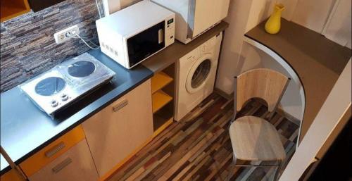 una pequeña cocina con microondas y lavadora. en Young Downtown Apartment en Arad