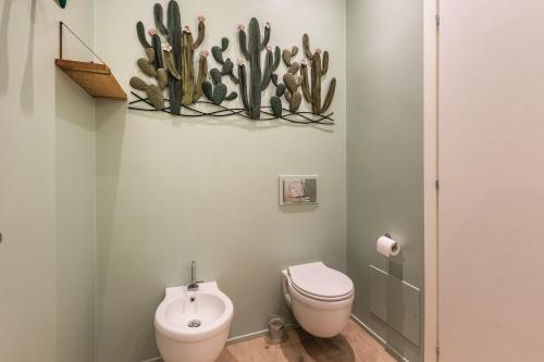 a bathroom with a toilet and a cactus on the wall at ANNA'S DREAM BED & BREAKFAST in Avola