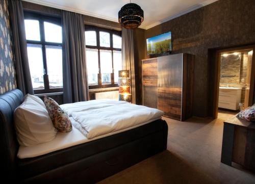 Hotel Sankt Wendel في بروم: غرفة نوم مع سرير في غرفة مع نوافذ