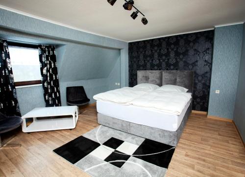 sypialnia z dużym białym łóżkiem i oknem w obiekcie Hotel Sankt Wendel w mieście Prüm