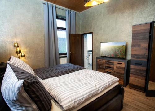 Hotel Sankt Wendel في بروم: غرفة نوم بسرير وتلفزيون بشاشة مسطحة