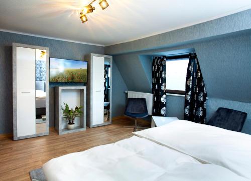 Hotel Sankt Wendel في بروم: غرفة نوم بسرير ابيض وغرفة بها مرايا