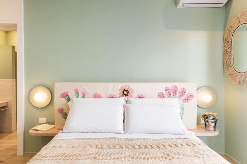 a bedroom with a white bed with a pink headboard at ANNA'S DREAM BED & BREAKFAST in Avola