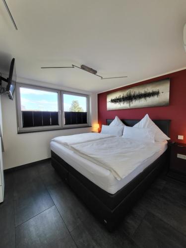a bedroom with a large bed with a red wall at Exklusive Wohnung mit Ahrblick 1 und Dachterrasse in Bad Neuenahr-Ahrweiler