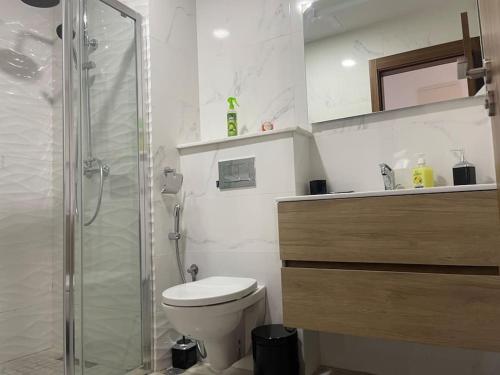 a bathroom with a toilet and a glass shower at Cosy central home near the beach in Agadir