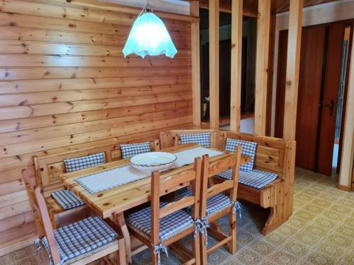 una sala da pranzo in legno con tavolo e sedie di Asiago Centro Trilocale Condominio BELLOCCHIO con Garage WiFi PetFriendly ad Asiago