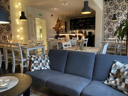 a living room with a blue couch and a table at Hedenstugan B&B Hotel in Bergby