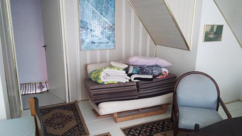 ein Zimmer mit einem Stuhl und einer Bank mit Kleidung darauf in der Unterkunft SUBASA GREEN GARDEN in Szeged
