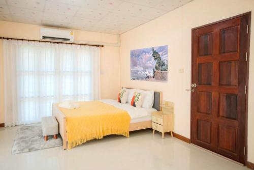 1 dormitorio con cama, ventana y puerta en ที่พักสงขลา Homy garden Songkhla, en Ban Khao Rup Chang