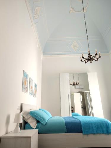 a bedroom with a blue bed and a mirror at Dimora della Marchesa - al Duomo in Manfredonia