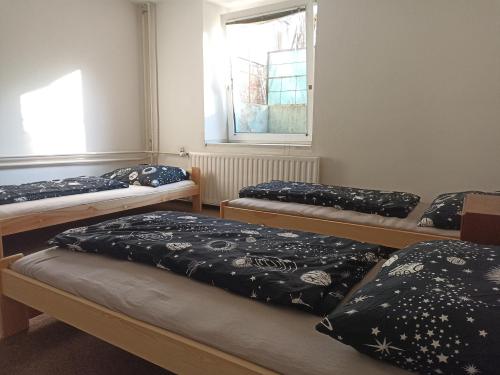 a group of three beds in a room at Štolcova room in Komárov