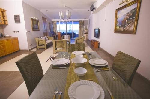 ein Esszimmer mit einem Tisch mit Tellern darauf in der Unterkunft Burnas Beach in Pereybere