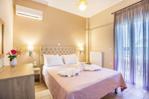 1 dormitorio con 1 cama con sábanas blancas y ventana en Georgia' s Apartment No1, en Máleme