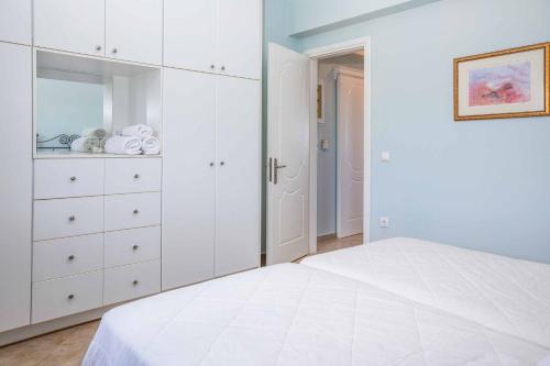 a white bedroom with a white dresser and a bed at Villa Alba Minies in Minia