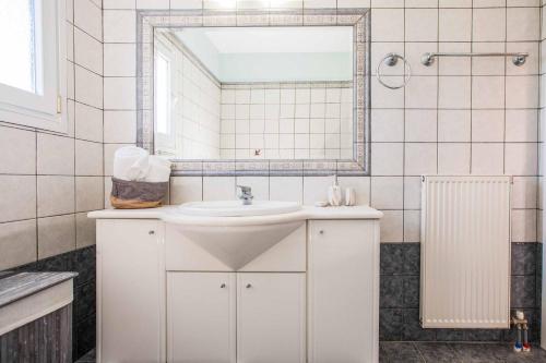 a white bathroom with a sink and a mirror at Villa Alba Minies in Minia