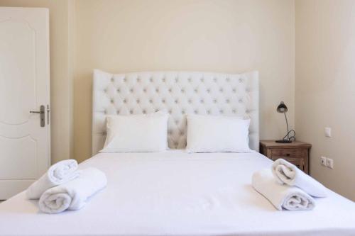a bedroom with a white bed with towels on it at Villa Alba Minies in Minia