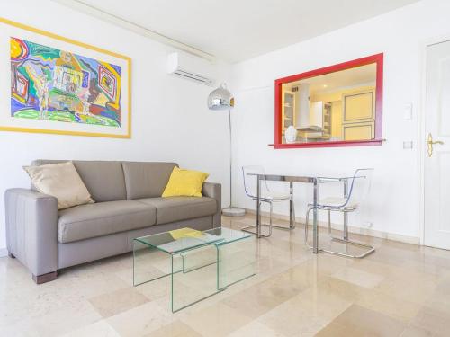 ein Wohnzimmer mit einem Sofa und einem Tisch in der Unterkunft Lovely One bedroom Colony in Cannes