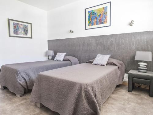 ein Schlafzimmer mit 2 Betten und einem Tisch mit einer Lampe in der Unterkunft Lovely One bedroom Colony in Cannes