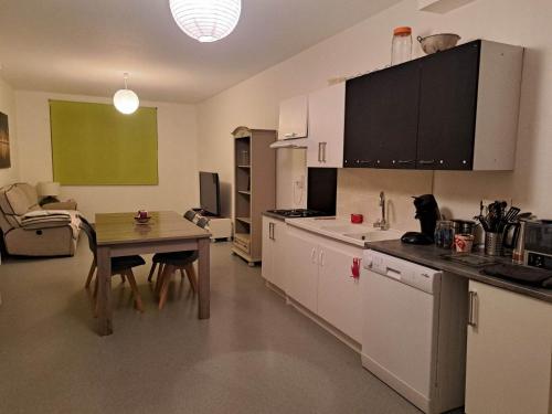 een keuken met een kleine tafel en een keuken met een eetkamer bij Chambre privative dans un grand appartement in Langres