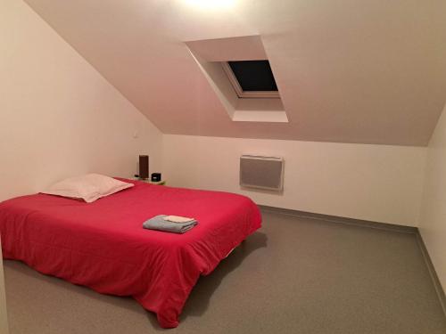 een slaapkamer met een rood bed en een rode deken bij Chambre privative dans un grand appartement in Langres