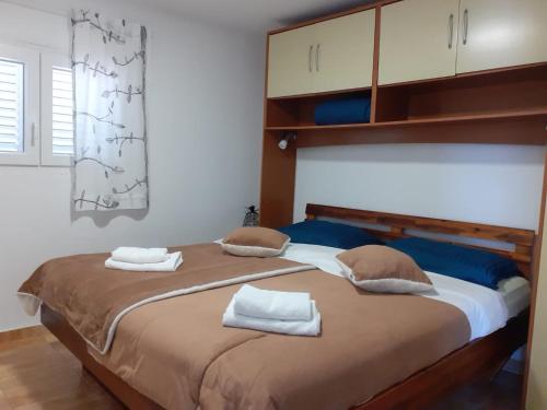 1 dormitorio con 1 cama grande y toallas. en Villa PANORAMA, en Pag