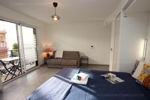 une chambre avec un lit et un salon avec un canapé dans l'établissement Carre Ginger, à Cannes