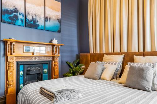 a bed with pillows and a fireplace in a room at Rawsons shack Beachfront unit suits single or couple in Henley Beach South