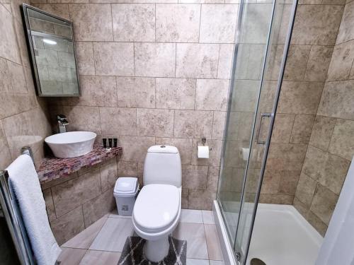 y baño con aseo, lavabo y ducha. en 16A Ground floor setup for your most amazing relaxed stay Free Parking Free Fast WiFi, en Morley