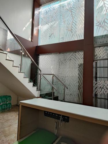 a bathroom with a sink and a staircase with glass at RAAJ PEARL in Chennai