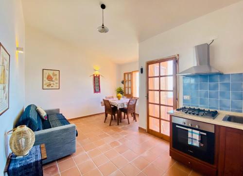 uma cozinha com um sofá e uma mesa num quarto em Panoramica casa al mare em Bosa