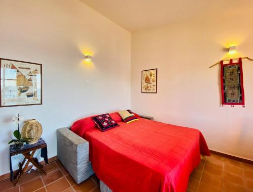 een slaapkamer met een rood bed in een kamer bij Panoramica casa al mare in Bosa