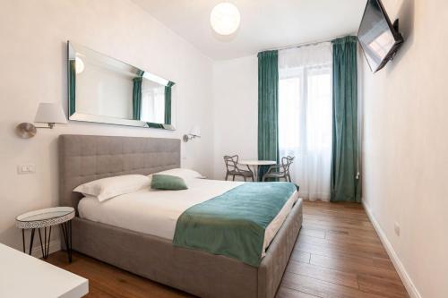 a bedroom with a bed with a mirror and a table at La finestra sul canale in Bologna