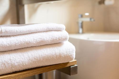 - une rangée de serviettes blanches sur une table dans la salle de bains dans l'établissement La finestra sul canale, à Bologne