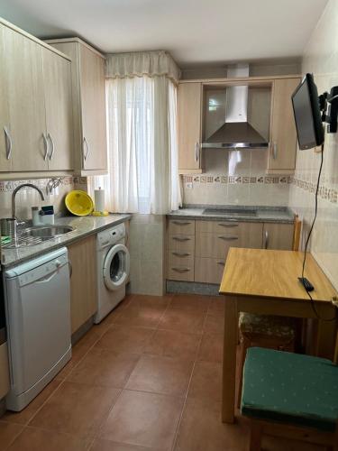 a kitchen with a sink and a washing machine at Casa Tia Angelita in Aguilar de la Frontera