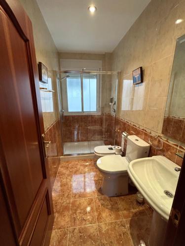 a bathroom with two toilets and a sink and a shower at Casa Tia Angelita in Aguilar de la Frontera