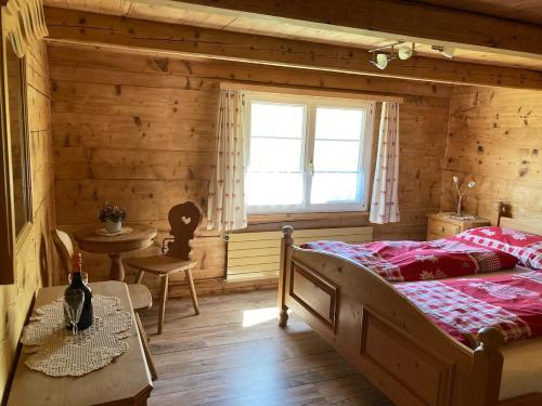 Schlafzimmer mit einem Bett, einem Tisch und einem Fenster in der Unterkunft Bauernhaus Cafrida in Flumserberg