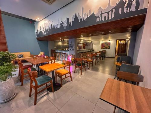 a restaurant with tables and chairs in a room at Monsoon Riverside Hotel in Phnom Penh