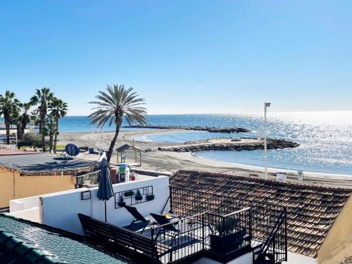 Blick auf einen Strand mit einer Palme und das Meer in der Unterkunft MalagadeVacaciones - Casa pulpo in Málaga