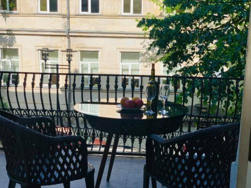 a table with a bowl of fruit and a bottle of wine at Belona Hotel in Kutaisi