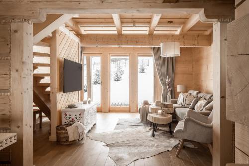 a living room with a couch and a tv at Osada Roztoki - Luxury Chalets in Kościelisko