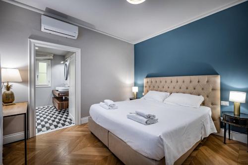 a bedroom with a large bed with towels on it at Hs4U Ricasoli Luxury apartment near Duomo N. 3 in Florence