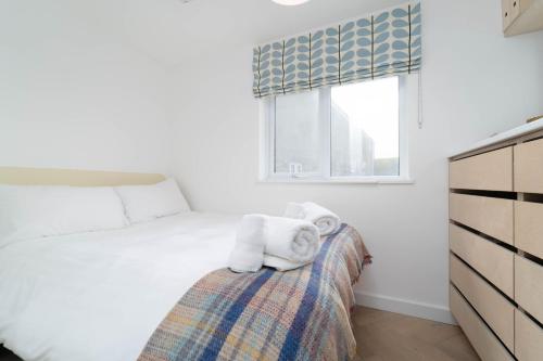 a bedroom with a bed with towels on it at 8 Beach Court in St Ives