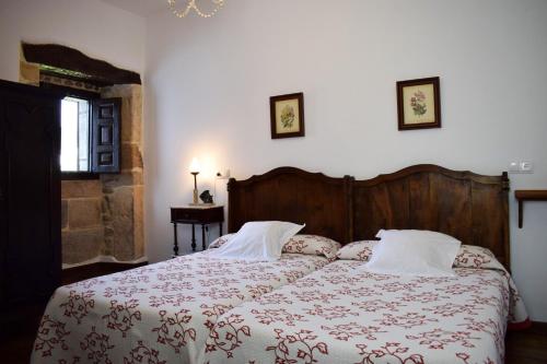 a bedroom with a bed with a red and white blanket at Apartamentos Casona de Linares in Selaya