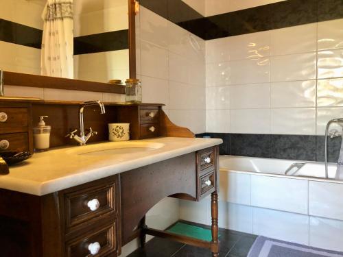 a bathroom with a sink and a bath tub at Traditional House at Aegina Port in Egina