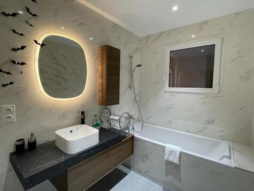 a bathroom with a sink and a tub and a mirror at NEW - Bat'Appart - DIJON - Insolite in Longvic