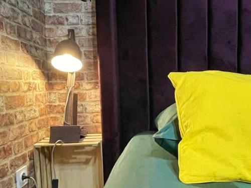 a lamp on a night stand next to a bed at NEW - Bat'Appart - DIJON - Insolite in Longvic