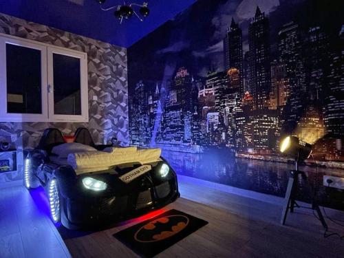 a bedroom with a bed with a car on the floor at NEW - Bat'Appart - DIJON - Insolite in Longvic